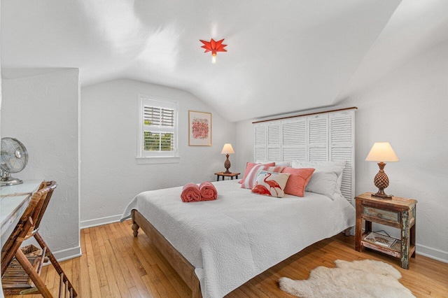 bedroom featuring light hardwood / wood-style floors and lofted ceiling