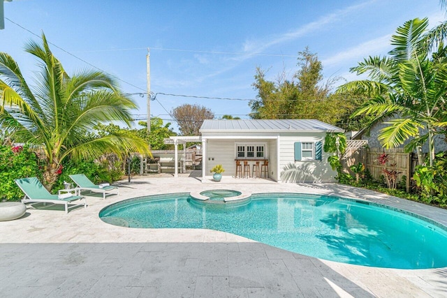 view of swimming pool featuring an in ground hot tub, an outbuilding, and a patio