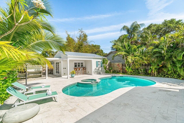 view of pool with a patio area, an outdoor structure, and an in ground hot tub