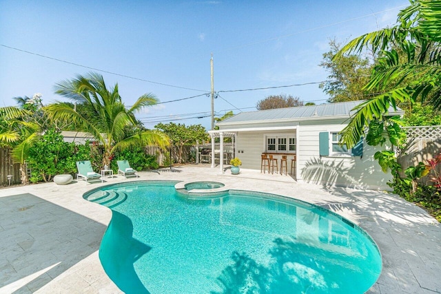 view of pool with an in ground hot tub, an outdoor bar, and a patio area