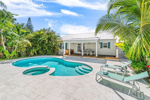 view of pool featuring a patio area and an in ground hot tub