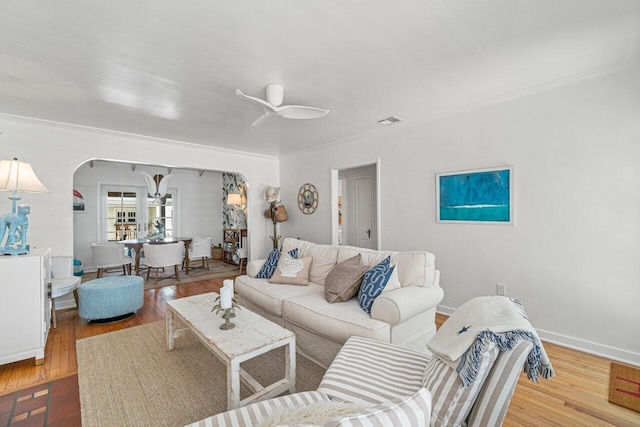 living room featuring light wood-type flooring, ceiling fan, and ornamental molding