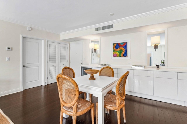 dining space with ornamental molding, beverage cooler, and dark wood-type flooring