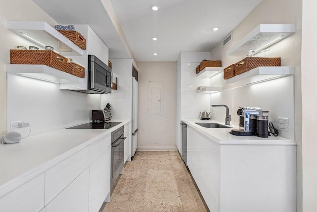 kitchen featuring black appliances, white cabinets, and sink