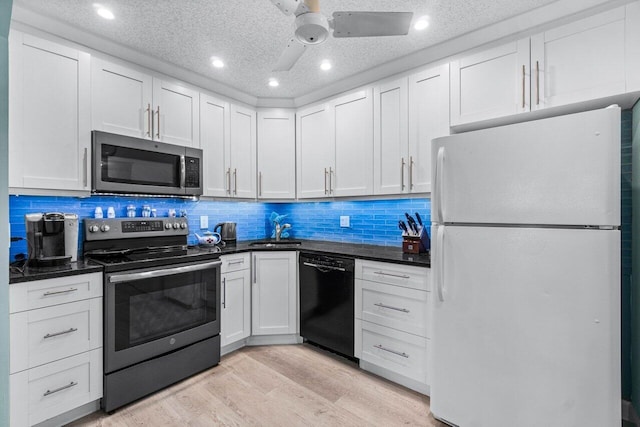 kitchen featuring light wood-type flooring, a textured ceiling, stainless steel appliances, sink, and white cabinetry