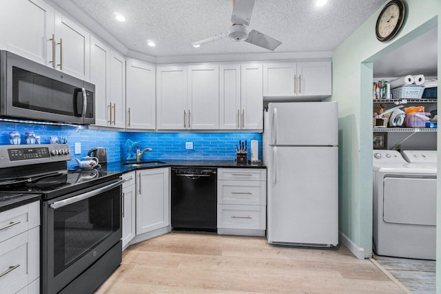 kitchen featuring white cabinets, appliances with stainless steel finishes, a textured ceiling, and washing machine and dryer