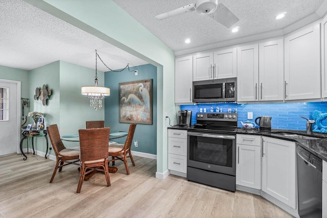 kitchen with a textured ceiling, stainless steel appliances, sink, light hardwood / wood-style floors, and white cabinetry