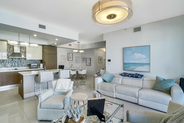 tiled living room featuring a chandelier