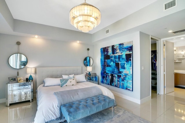 tiled bedroom with ensuite bath and a chandelier