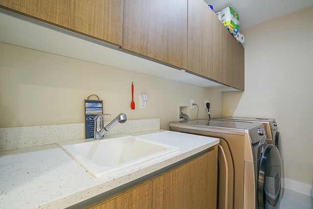 laundry room with cabinets, separate washer and dryer, and sink