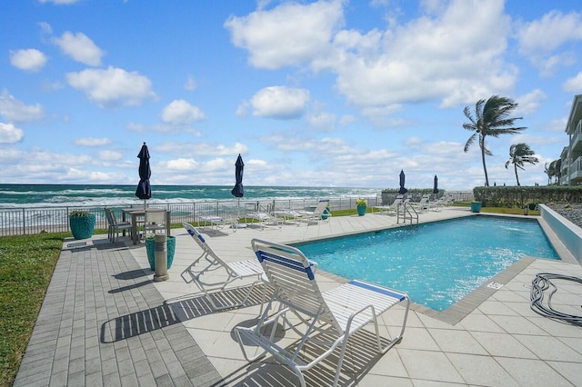 view of pool featuring a water view and a patio area