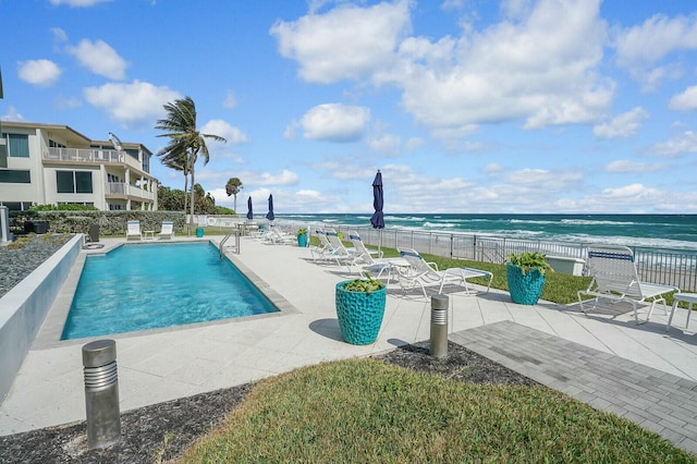 view of swimming pool featuring a water view and a patio