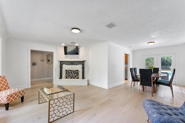 kitchen with sink, crown molding, light stone counters, a textured ceiling, and pendant lighting