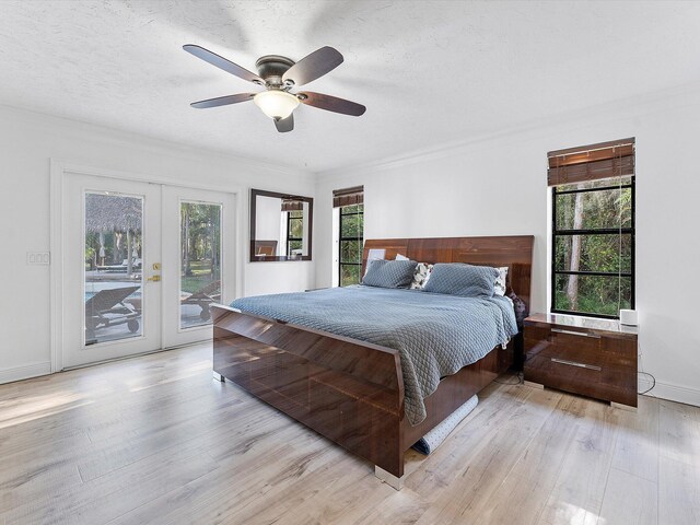 bedroom with access to outside, light hardwood / wood-style floors, ceiling fan, a textured ceiling, and french doors