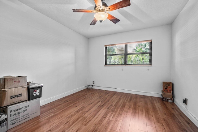 spare room with ceiling fan, wood-type flooring, and a textured ceiling