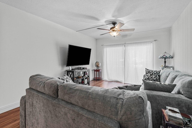 living room with hardwood / wood-style flooring, ceiling fan, and a textured ceiling