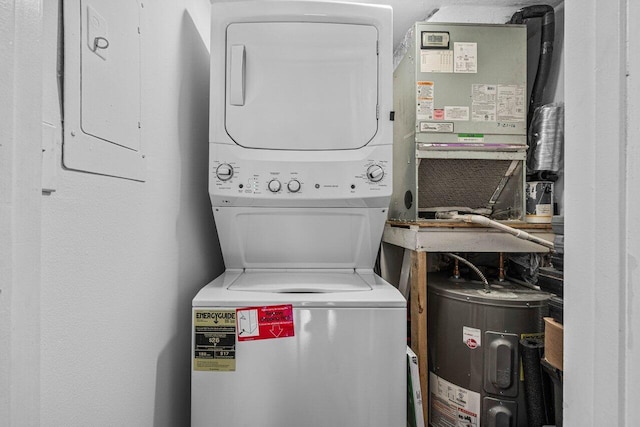 laundry area featuring electric water heater and stacked washer / dryer