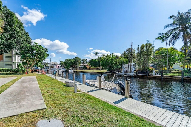 view of dock with a water view and a yard