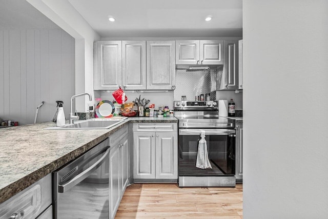 kitchen featuring white cabinetry, sink, stainless steel appliances, and light wood-type flooring