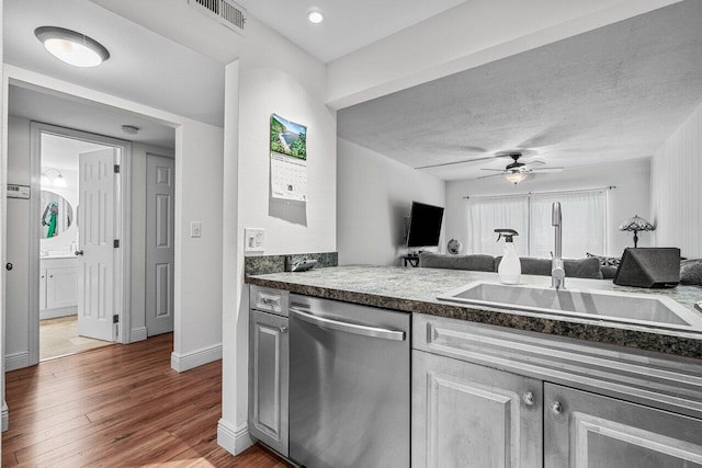 kitchen with stainless steel dishwasher, ceiling fan, sink, and hardwood / wood-style flooring