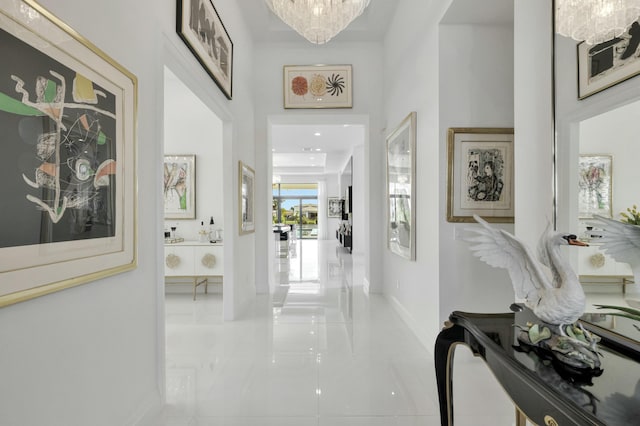 hallway with a towering ceiling and an inviting chandelier