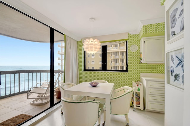 tiled dining space featuring a water view and a notable chandelier