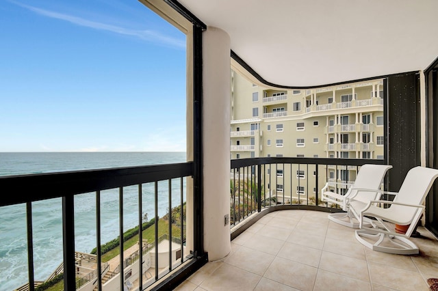 balcony featuring a water view and a view of the beach