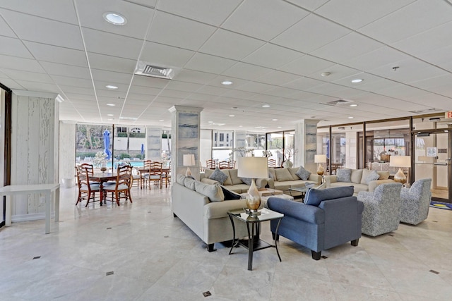 living room featuring floor to ceiling windows and a paneled ceiling