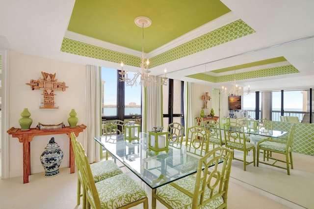 dining room with a raised ceiling, a wealth of natural light, and a notable chandelier