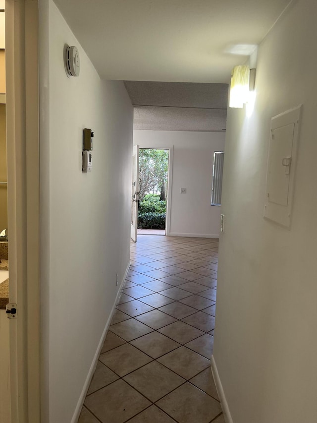 hallway with electric panel and light tile patterned floors