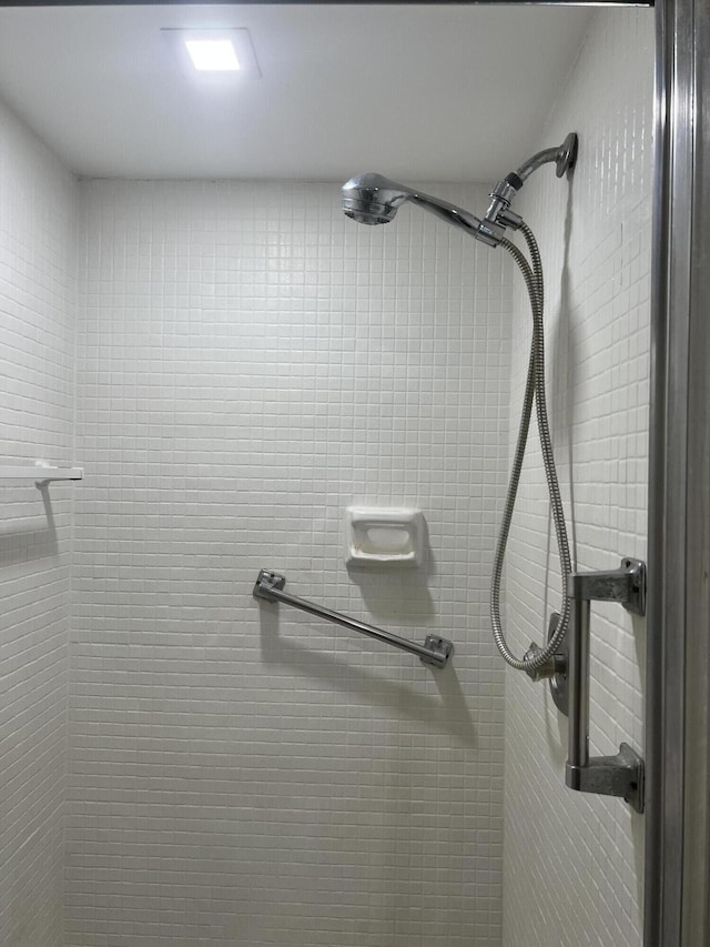 interior details featuring tiled shower