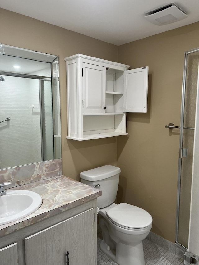 bathroom featuring tile patterned floors, vanity, toilet, and walk in shower