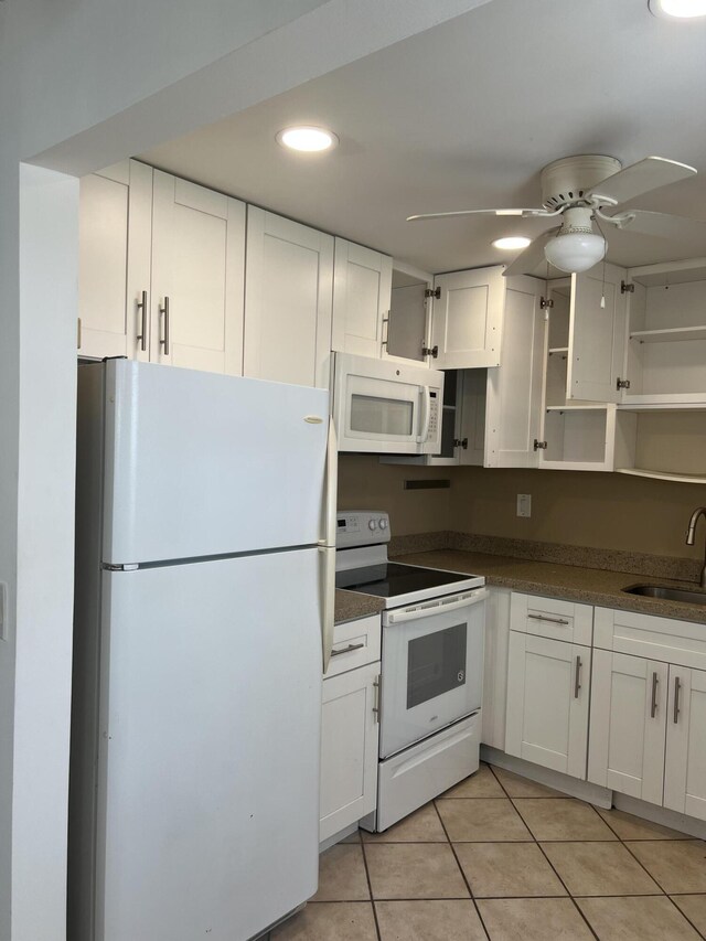 kitchen with white cabinets, white appliances, light tile patterned flooring, and sink