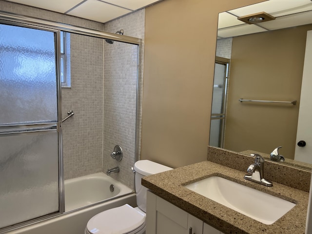 full bathroom featuring vanity, toilet, and bath / shower combo with glass door