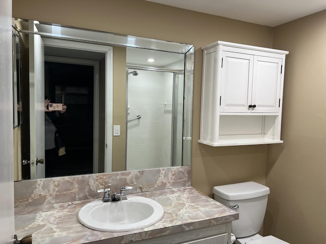 bathroom featuring toilet, vanity, and walk in shower