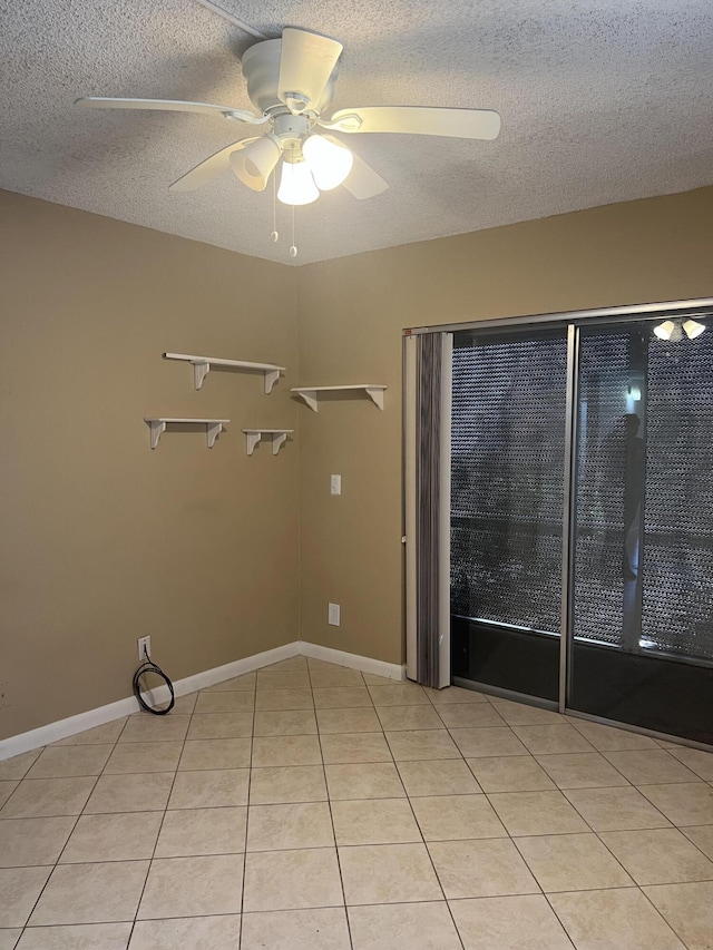 interior space with ceiling fan, light tile patterned flooring, and a textured ceiling