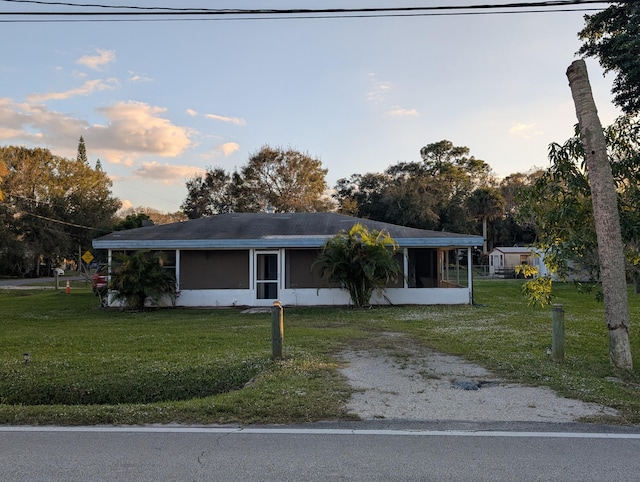 ranch-style home with a yard and a sunroom