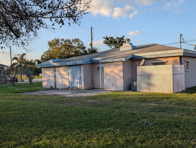 back of property with a yard and a patio