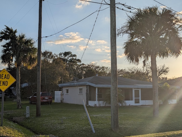 property exterior at dusk featuring a yard