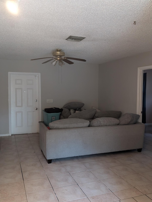 tiled living room with ceiling fan and a textured ceiling