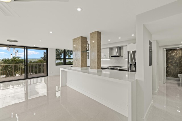 kitchen featuring recessed lighting, white cabinets, appliances with stainless steel finishes, wall chimney exhaust hood, and modern cabinets