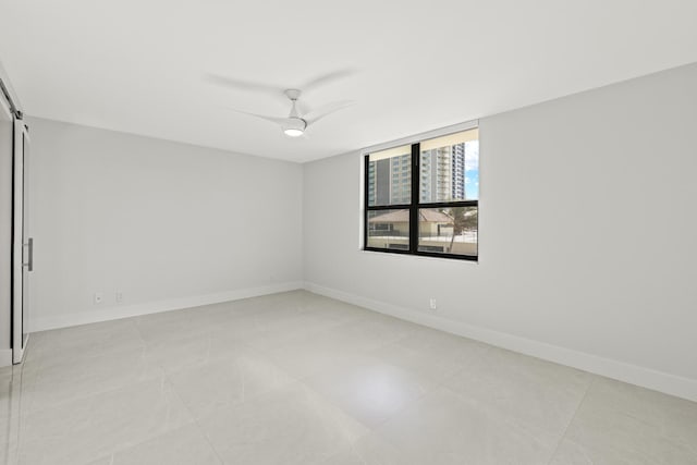 unfurnished room featuring ceiling fan and baseboards