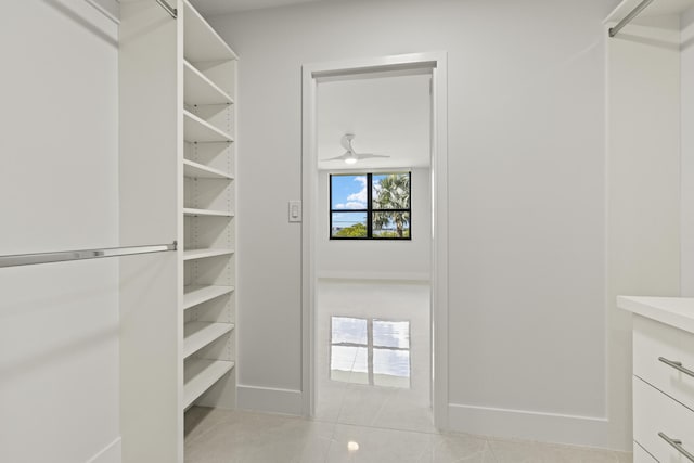 walk in closet with light tile patterned floors and ceiling fan