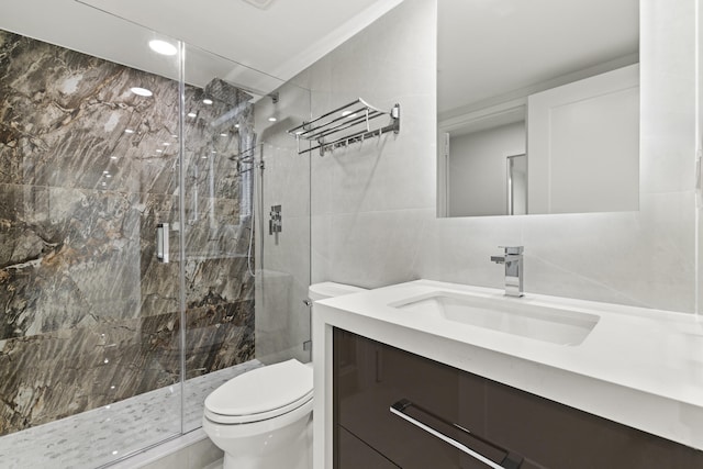 bathroom with an enclosed shower, vanity, toilet, and tile walls