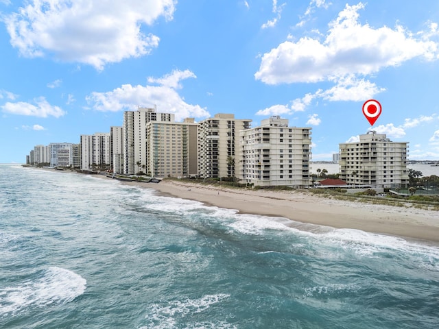 view of property featuring a view of the beach, a water view, and a city view