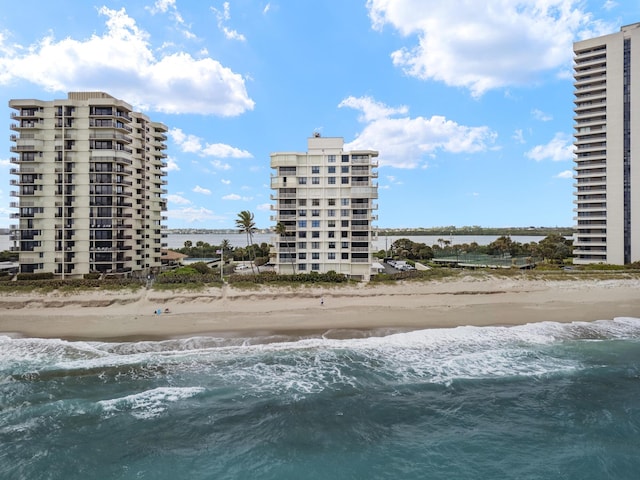 view of building exterior with a water view and a beach view