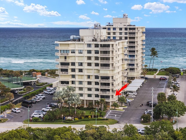 view of building exterior with a water view and uncovered parking