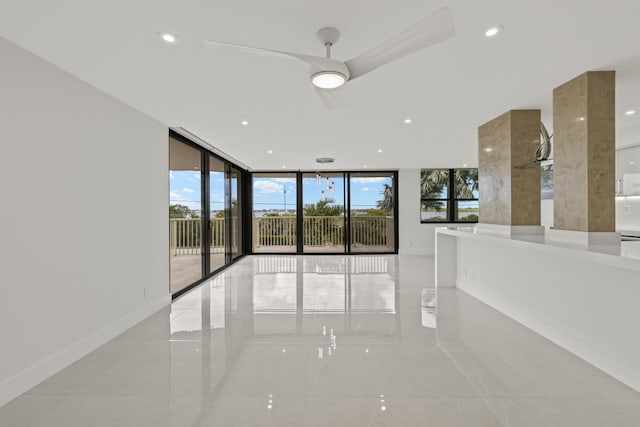 empty room with expansive windows, ceiling fan, baseboards, and recessed lighting