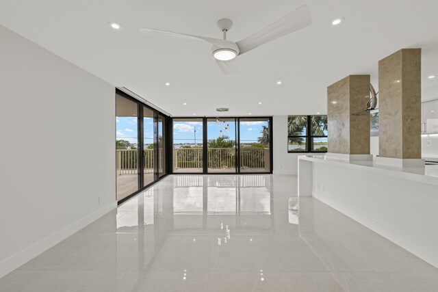 spare room featuring ceiling fan and floor to ceiling windows