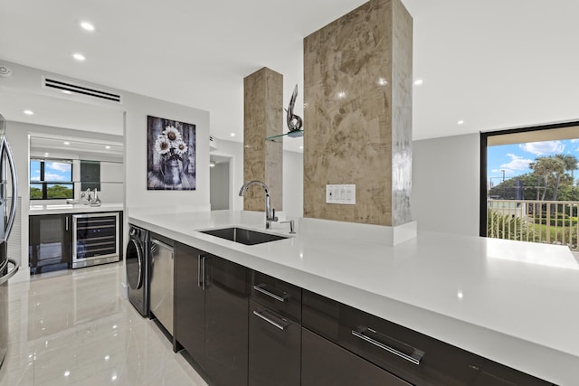 kitchen with washer / clothes dryer, wine cooler, stainless steel dishwasher, and sink